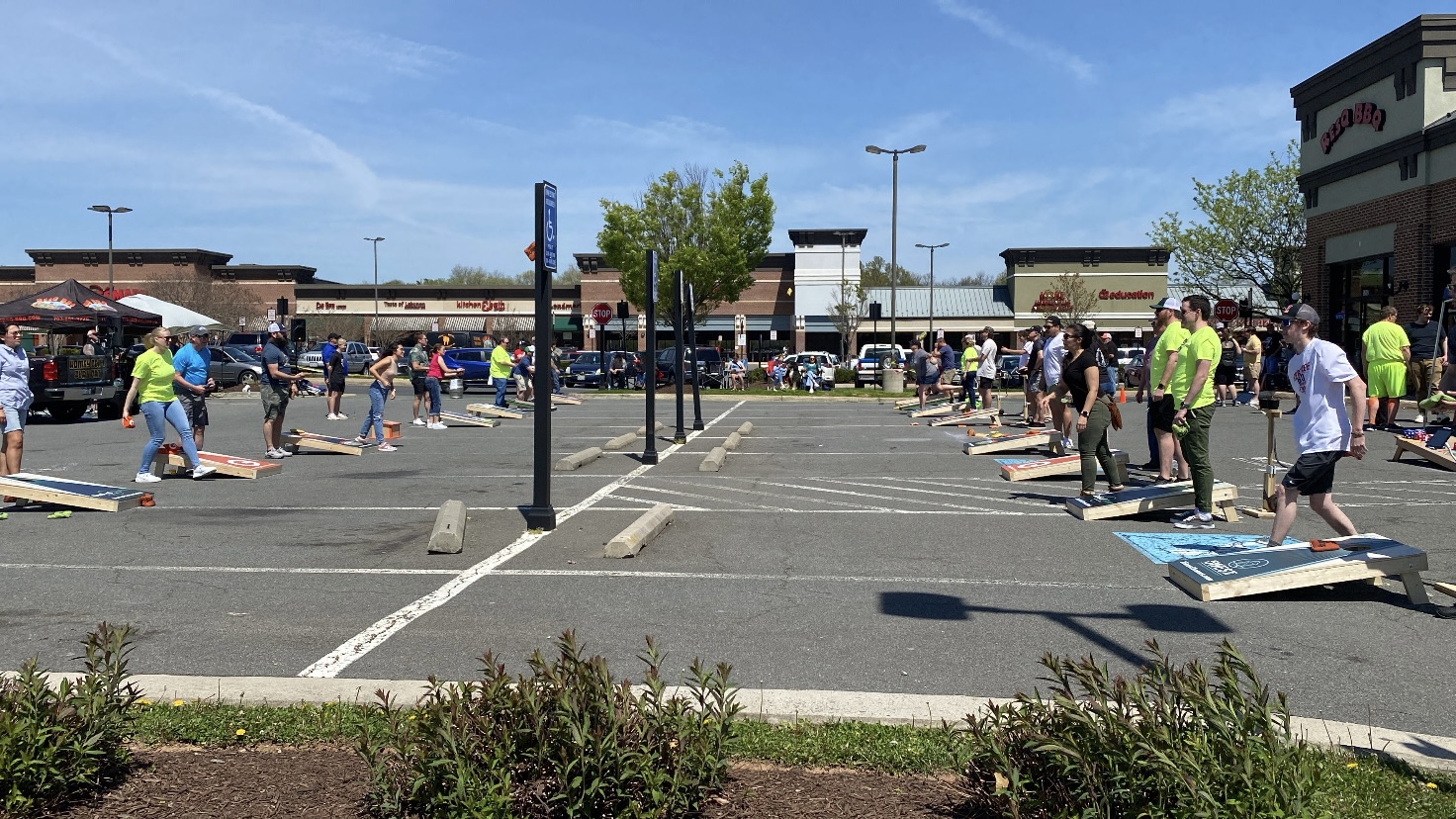 People playing cornhole in the parking lot at ResQ BBQ in Leesburg, Virginia